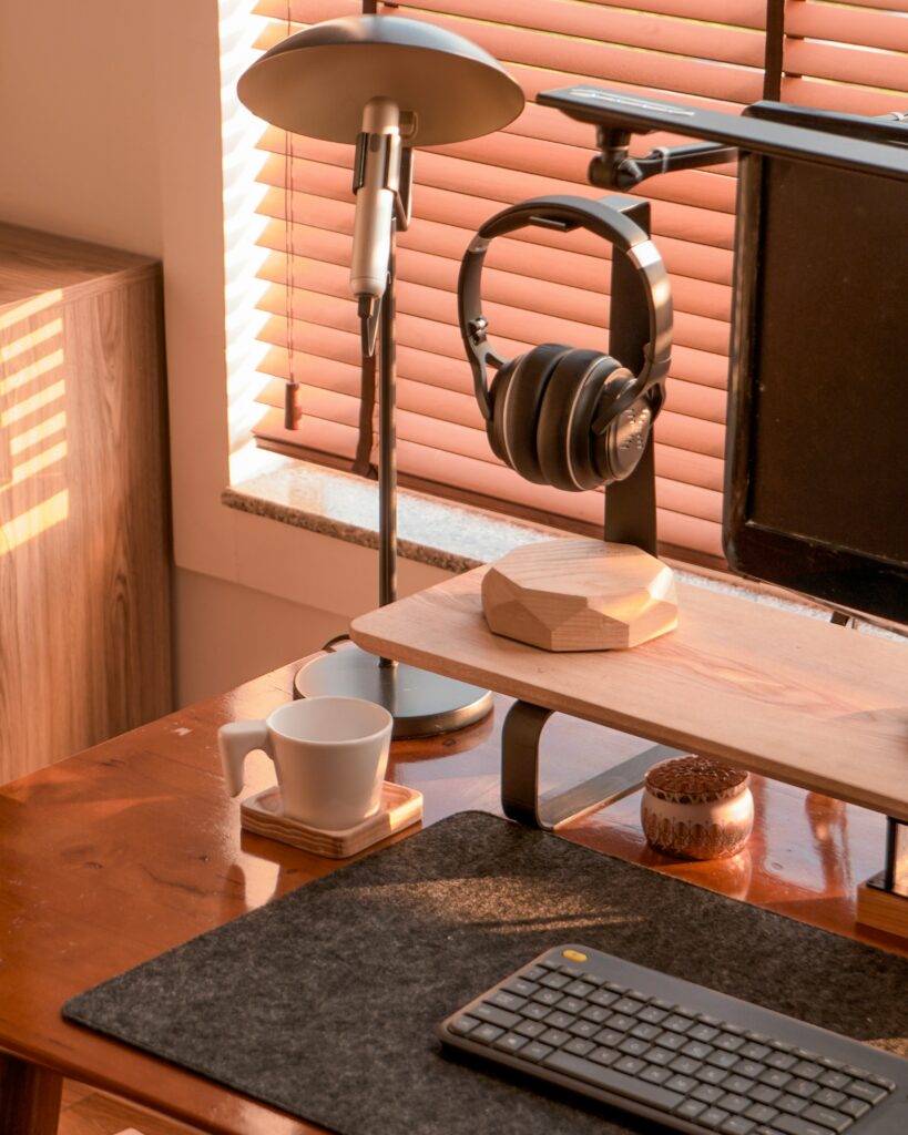 minimal home office desk setup with warm lighting, monitor stand, and clean workspace for remote work